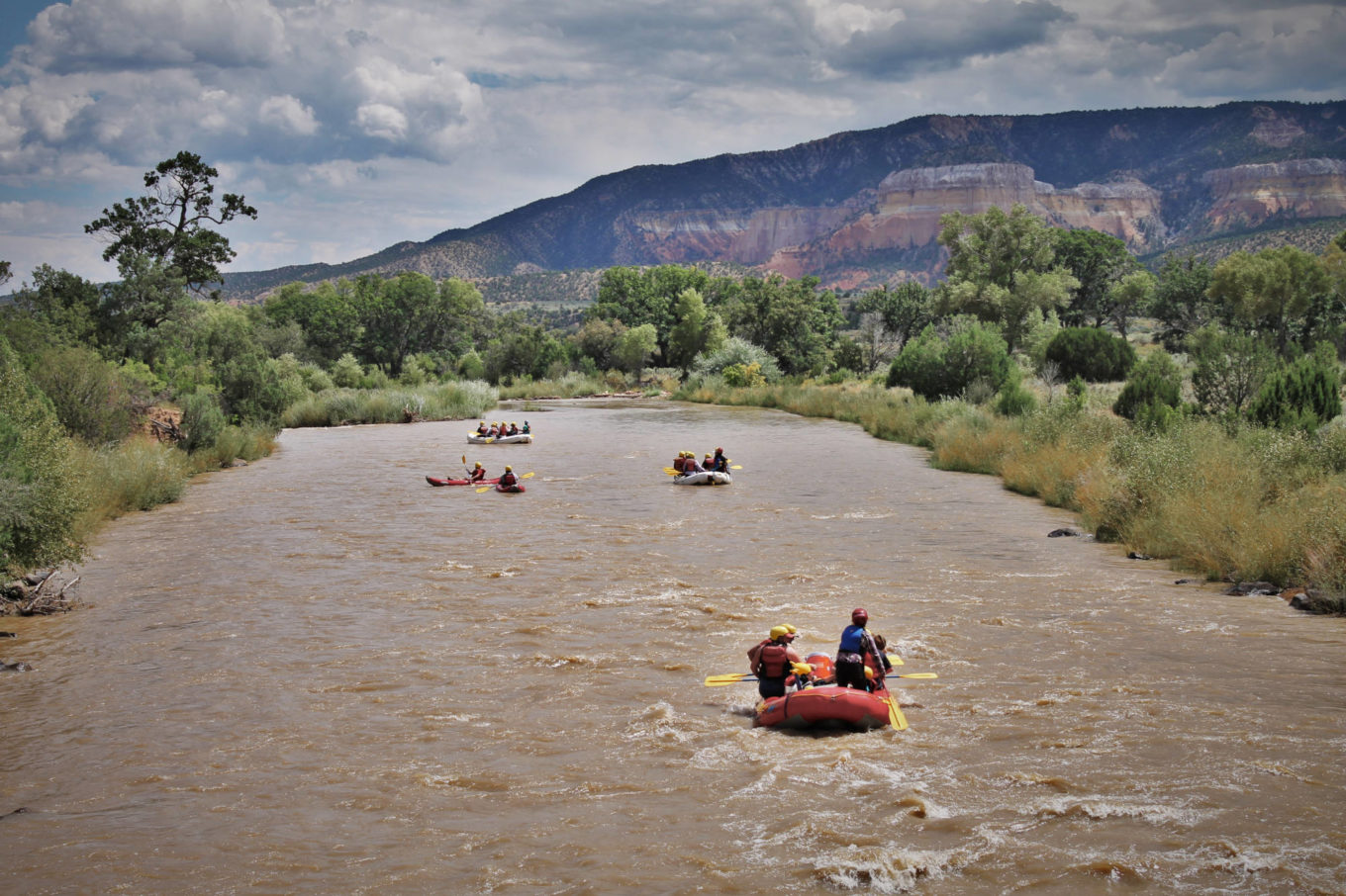 Many rafts on a new mexico yoga rafting retreat