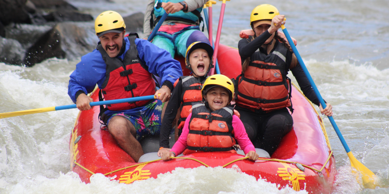 A family of four and a guide raft down the Rio Chama