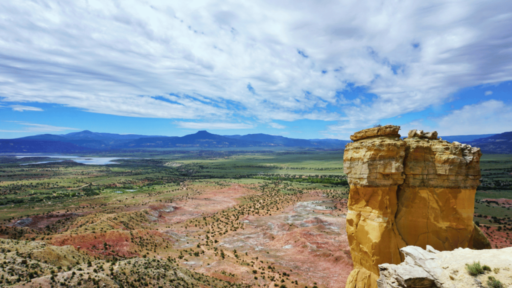 A rock tower in a expansive desert near Abiquiú .
